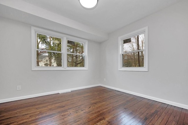 spare room with dark wood-style floors and baseboards