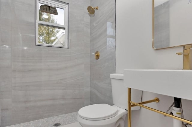 bathroom with toilet and a tile shower