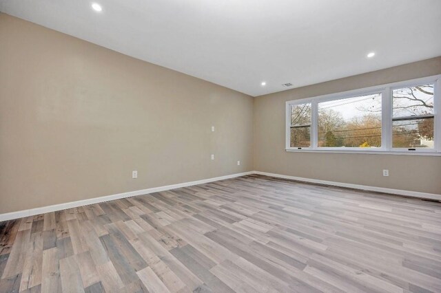 unfurnished room with light wood-style floors, visible vents, baseboards, and recessed lighting