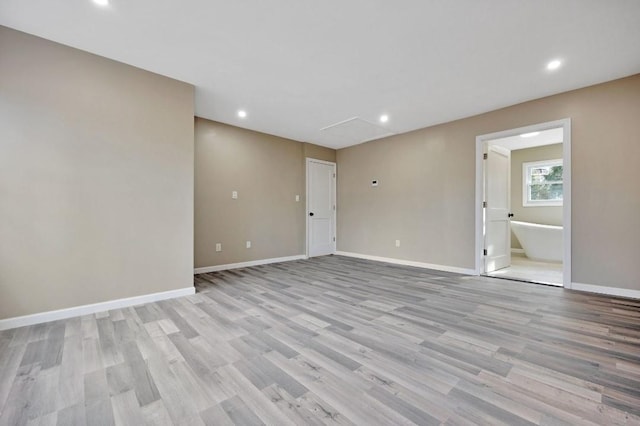 unfurnished room featuring recessed lighting, light wood-style flooring, and baseboards