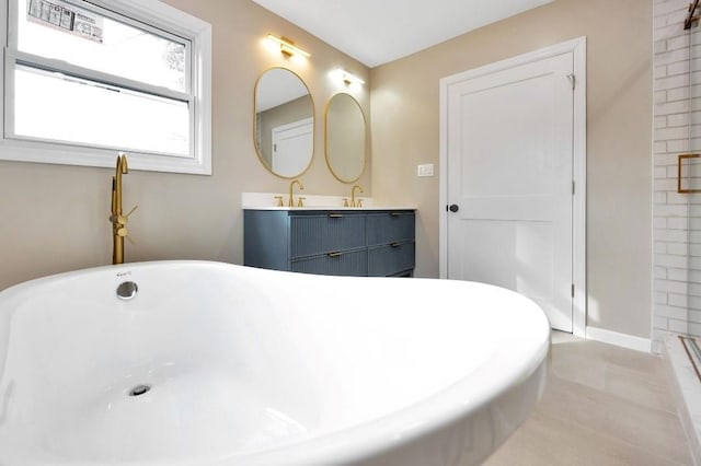 full bathroom with a soaking tub, a sink, baseboards, and double vanity