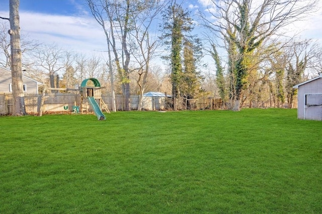 view of yard featuring a playground and a fenced backyard