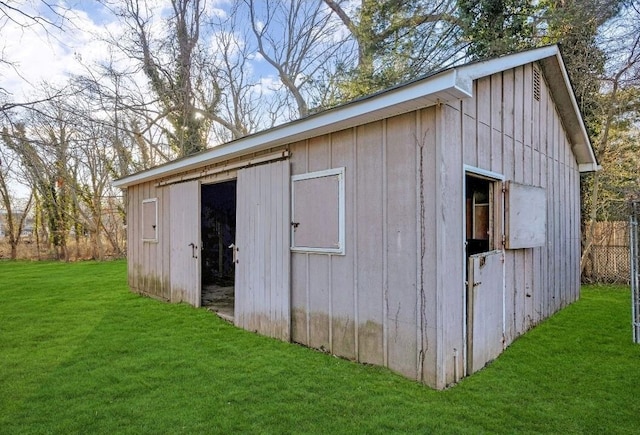 view of outdoor structure featuring fence and an outbuilding