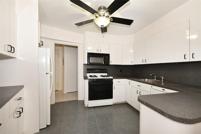 kitchen featuring white appliances, dark countertops, a sink, and white cabinetry