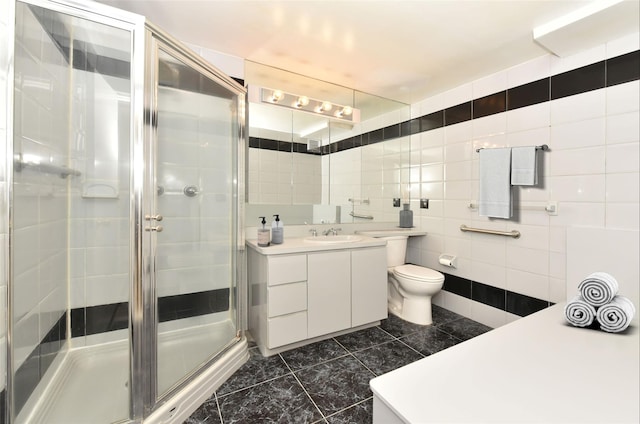 full bath with a stall shower, toilet, tile walls, and vanity