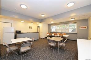 dining space featuring dark carpet