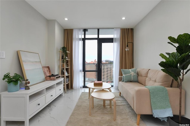 sitting room featuring a wall of windows, recessed lighting, and marble finish floor