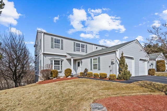 traditional-style house with driveway, a front lawn, and a garage