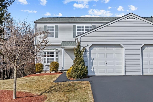 view of front facade featuring aphalt driveway, a front lawn, a garage, and a shingled roof