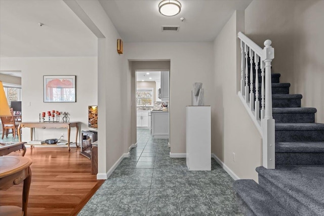 interior space with tile patterned floors, baseboards, and stairs