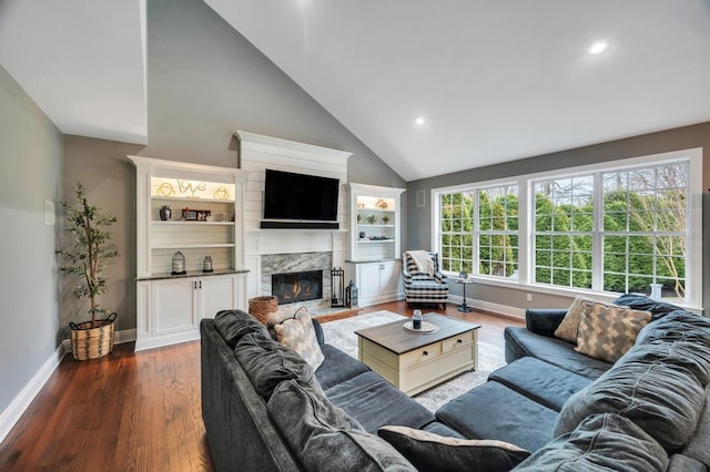 living room with a high end fireplace, baseboards, and dark wood-style flooring