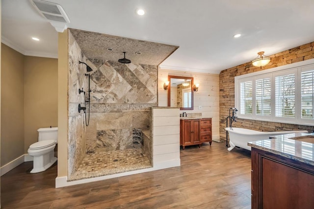 bathroom featuring vanity, wood finished floors, visible vents, a freestanding tub, and crown molding