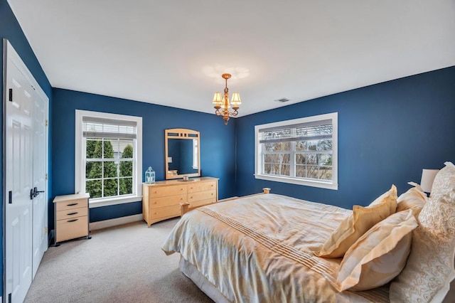 bedroom featuring visible vents, light carpet, a notable chandelier, a closet, and baseboards