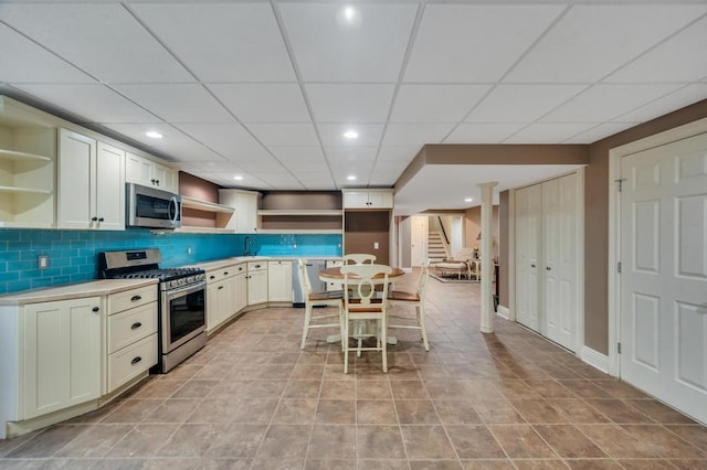 kitchen featuring open shelves, recessed lighting, stainless steel appliances, light countertops, and decorative backsplash