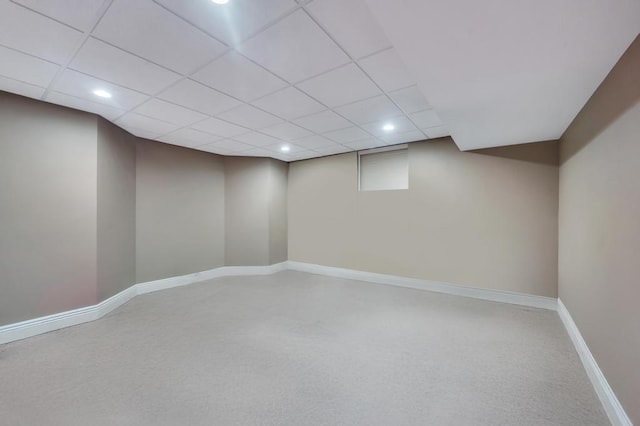 finished below grade area with recessed lighting, a paneled ceiling, baseboards, and carpet