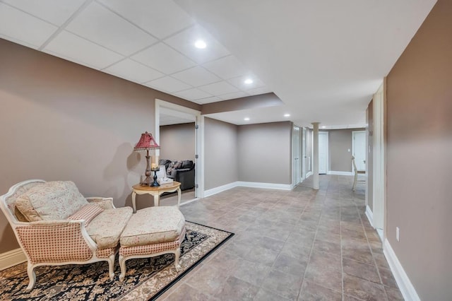 living area featuring recessed lighting, a paneled ceiling, and baseboards