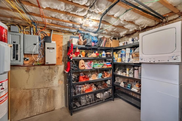 storage featuring electric panel, stacked washer / dryer, and water heater