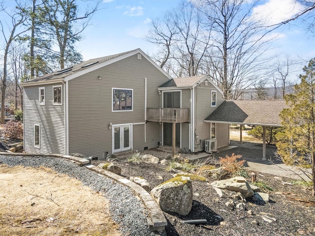 back of house with a carport, french doors, and roof with shingles