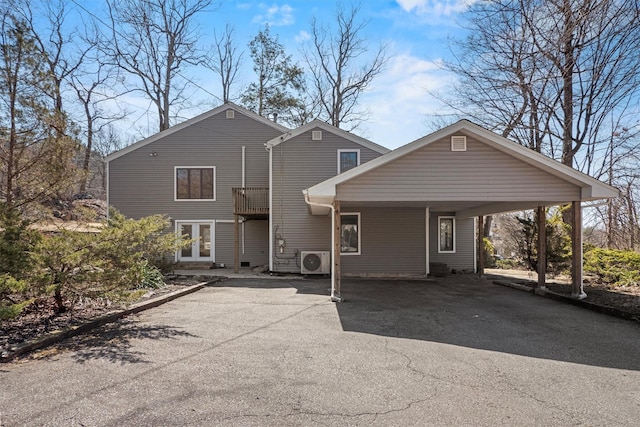 rear view of property featuring ac unit, aphalt driveway, an attached carport, and french doors