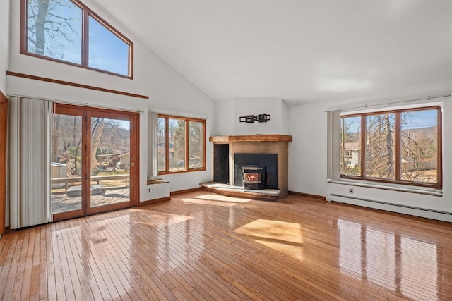 unfurnished living room featuring a baseboard heating unit, baseboards, hardwood / wood-style floors, and high vaulted ceiling