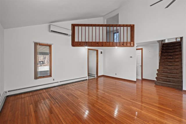 unfurnished living room featuring high vaulted ceiling, an AC wall unit, hardwood / wood-style floors, baseboard heating, and stairs