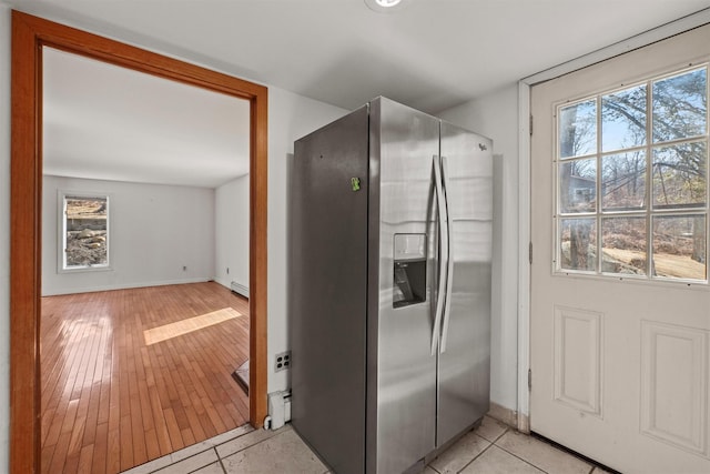 interior space featuring baseboards, stainless steel fridge, and baseboard heating