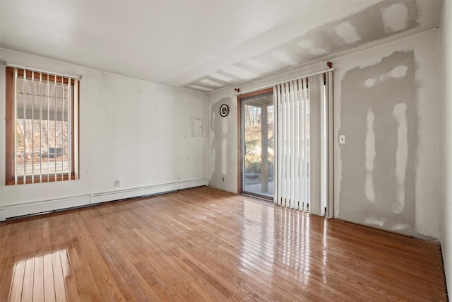 spare room featuring wood-type flooring and a baseboard radiator