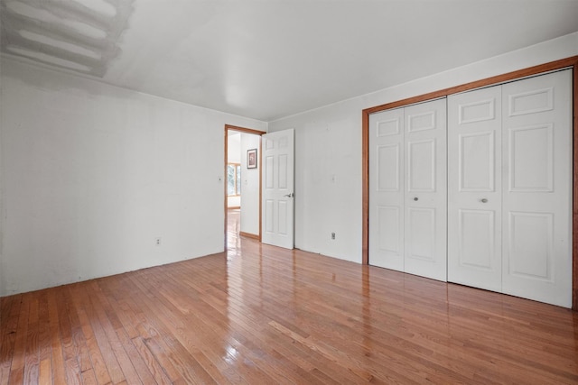 unfurnished bedroom with a closet and hardwood / wood-style floors