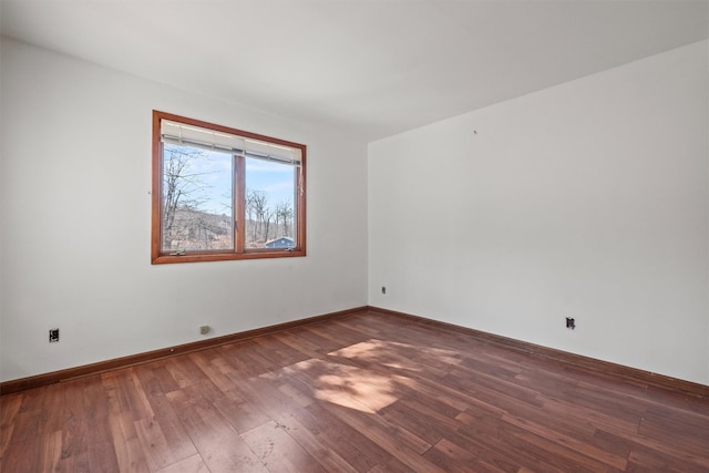 empty room with baseboards and wood finished floors