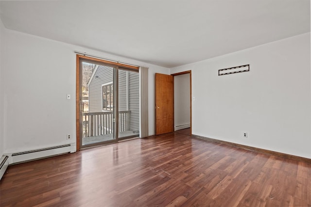 empty room with a baseboard heating unit, baseboards, and wood finished floors