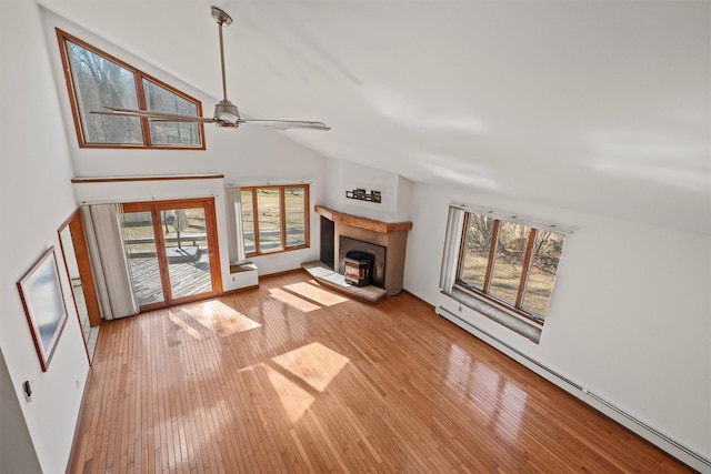 unfurnished living room featuring light wood finished floors, high vaulted ceiling, a ceiling fan, and a baseboard radiator