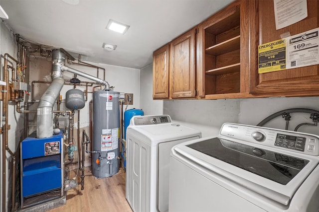 laundry area with a heating unit, gas water heater, light wood-type flooring, cabinet space, and separate washer and dryer