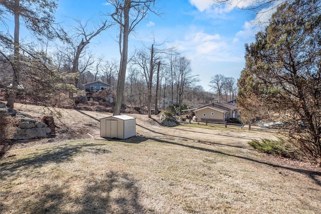 view of yard with an outbuilding, a storage unit, and fence