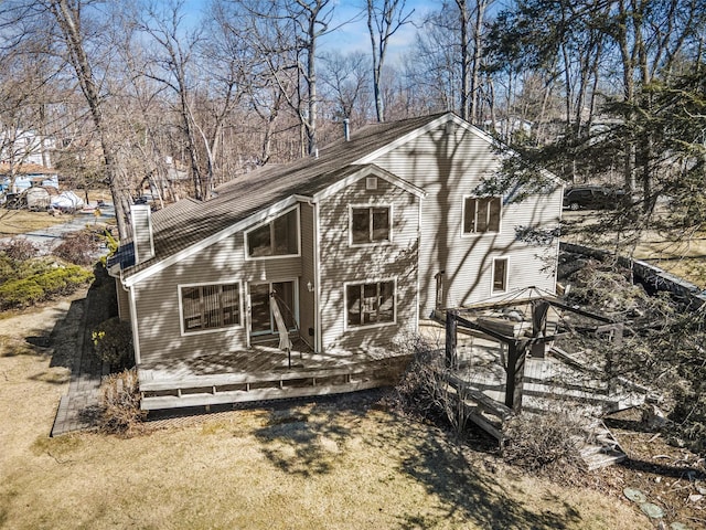 back of property with a wooden deck and a chimney