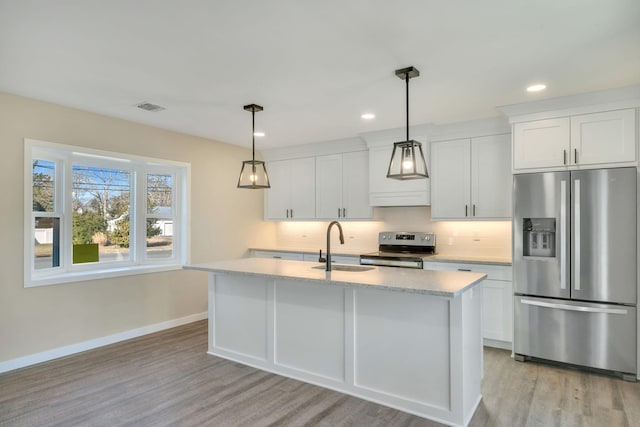 kitchen with stainless steel appliances, a sink, baseboards, light wood-type flooring, and decorative backsplash