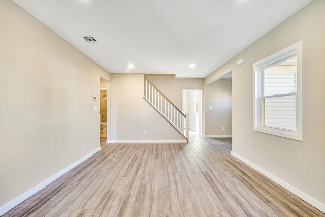 spare room with recessed lighting, visible vents, wood finished floors, baseboards, and stairs