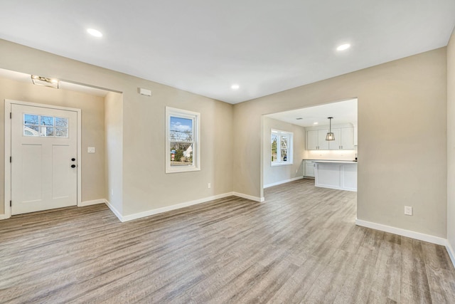 unfurnished living room featuring light wood-style flooring, baseboards, and recessed lighting