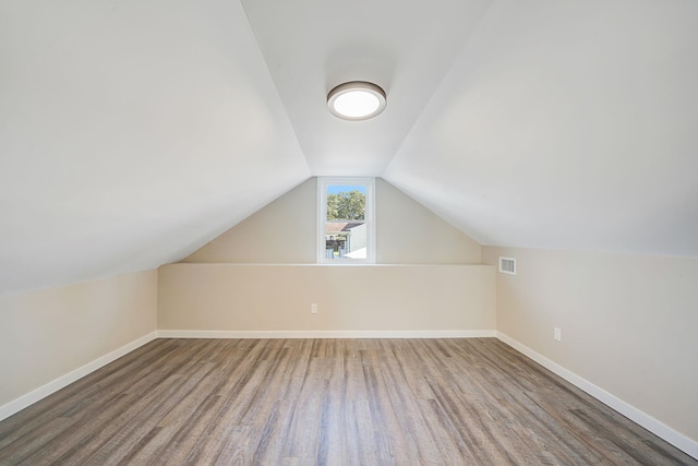 bonus room featuring vaulted ceiling, wood finished floors, visible vents, and baseboards