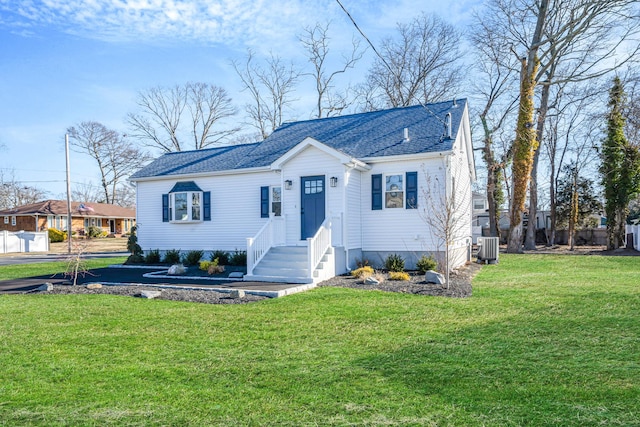 view of front of house with central air condition unit, a shingled roof, and a front lawn