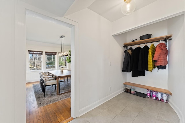 mudroom featuring baseboards, a notable chandelier, and light wood-style flooring