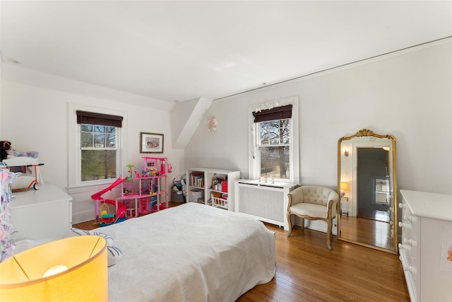 bedroom featuring radiator and wood finished floors