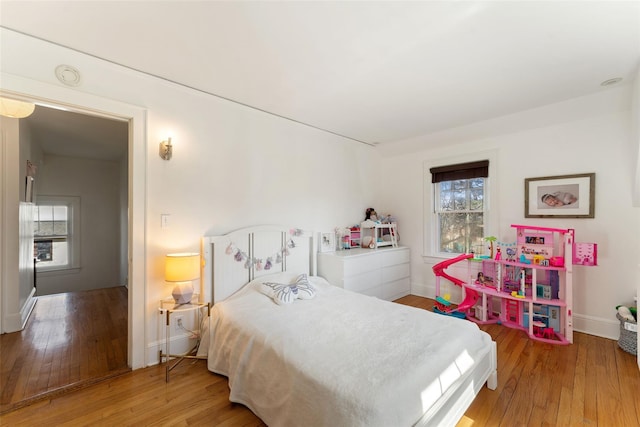 bedroom featuring hardwood / wood-style flooring and baseboards