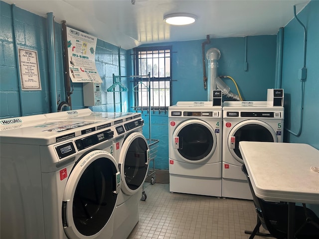 common laundry area with light tile patterned flooring and washer and clothes dryer