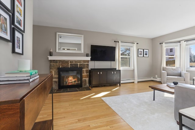 living area featuring a fireplace, wood finished floors, and baseboard heating