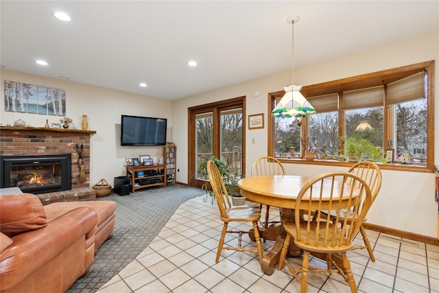 dining area with a brick fireplace, light tile patterned floors, recessed lighting, and baseboards