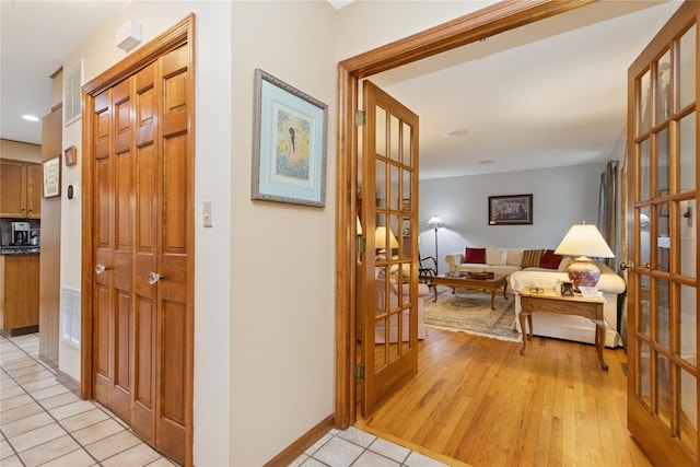 hall with light wood-type flooring and baseboards