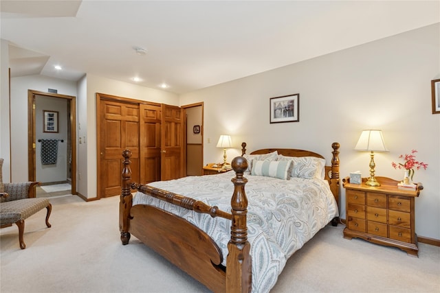 bedroom with a closet, recessed lighting, light carpet, and baseboards