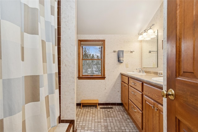 full bath with wallpapered walls, lofted ceiling, double vanity, a shower with curtain, and a sink