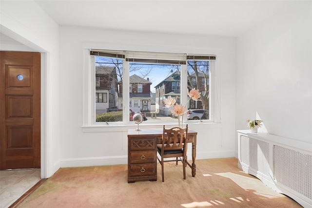 office area featuring a healthy amount of sunlight, radiator, baseboards, and carpet floors