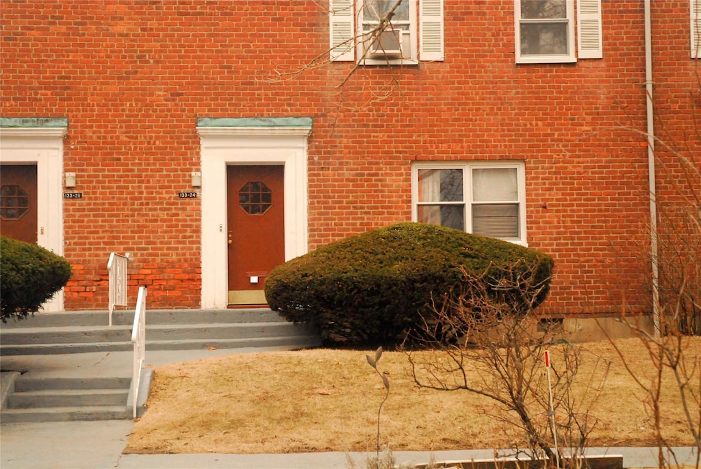 doorway to property featuring brick siding